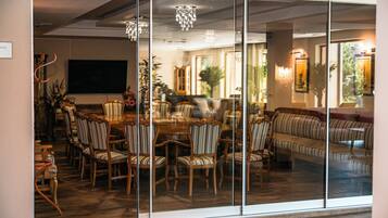Uma sala de jantar com uma mesa grande, várias cadeiras e um sofá.