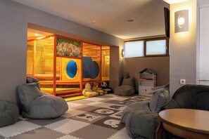 A cozy living room with a play area, including a trampoline and soft seating. - Hotel Skalite (Belogradchik)