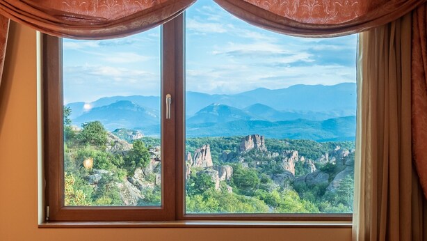 Una finestra con vista su un paesaggio montuoso.