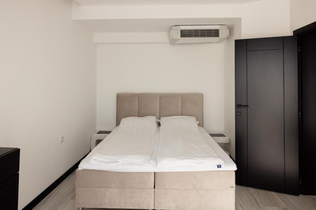 Un dormitorio minimalista con cama, mesita de noche y armario.