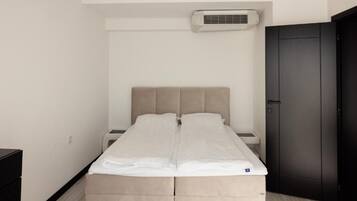 Un dormitorio minimalista con cama, mesita de noche y armario.