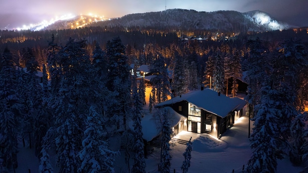 A snow-covered landscape with a cabin and a mountain in the background. - Villa Ailo - Quality Villa with Sauna & Jacuzzi (Kuusamo)