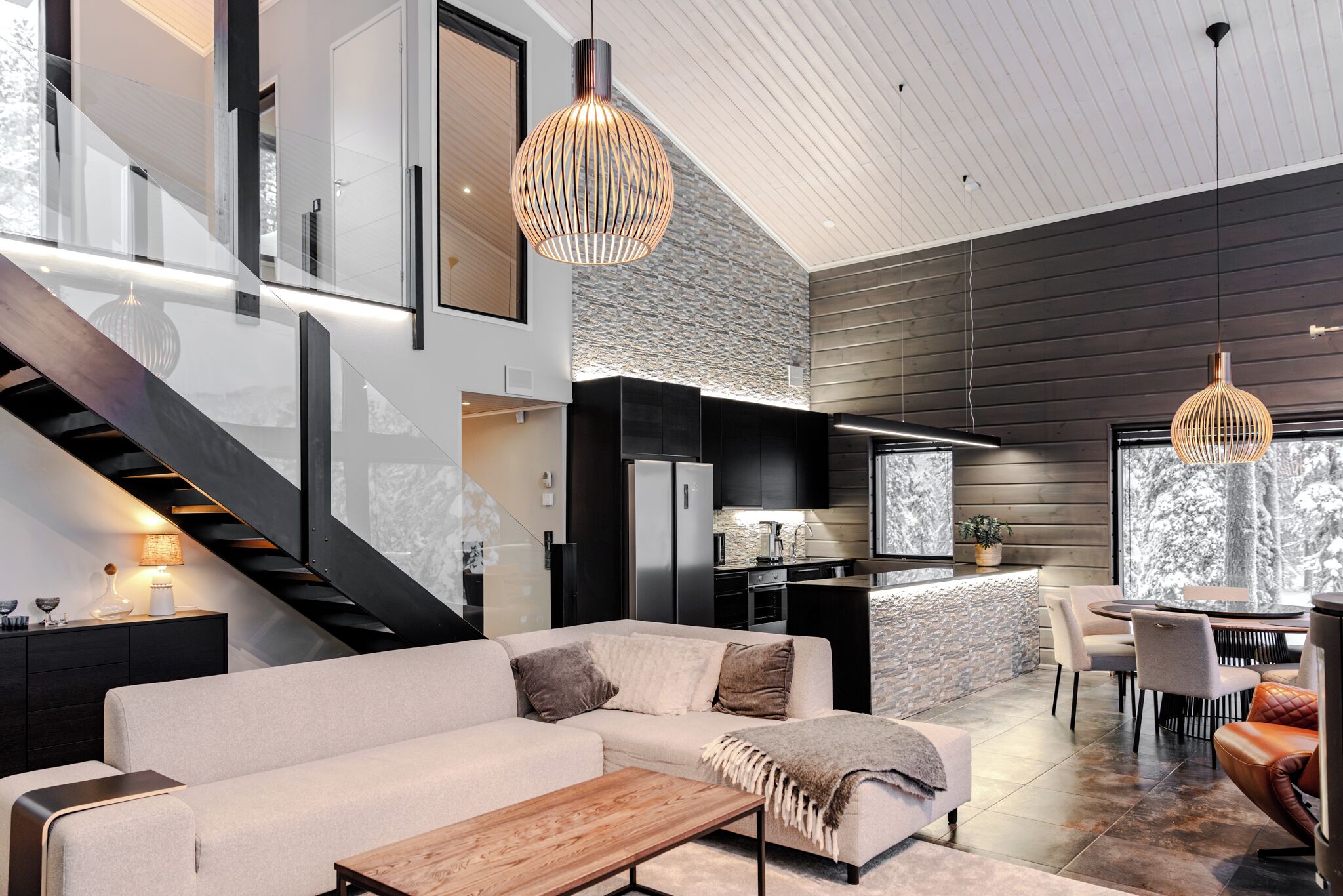 A modern interior with a staircase, a kitchen, and a dining area.
