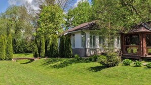 A house with a well-maintained lawn, a wooden deck, and a stone pathway leading to the entrance.
