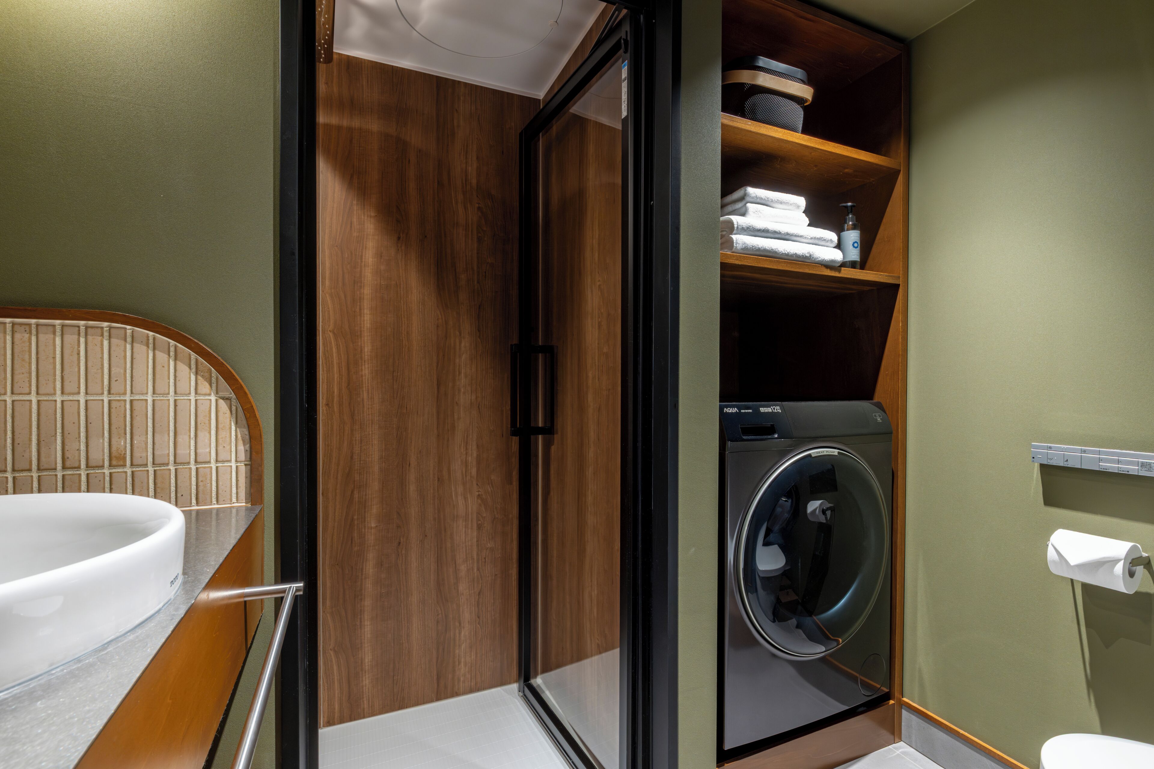A compact bathroom with a built-in washer and dryer, a toilet, and a sink.