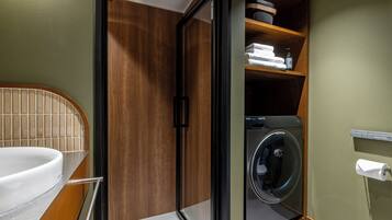 A compact bathroom with a built-in washer and dryer, a toilet, and a sink.