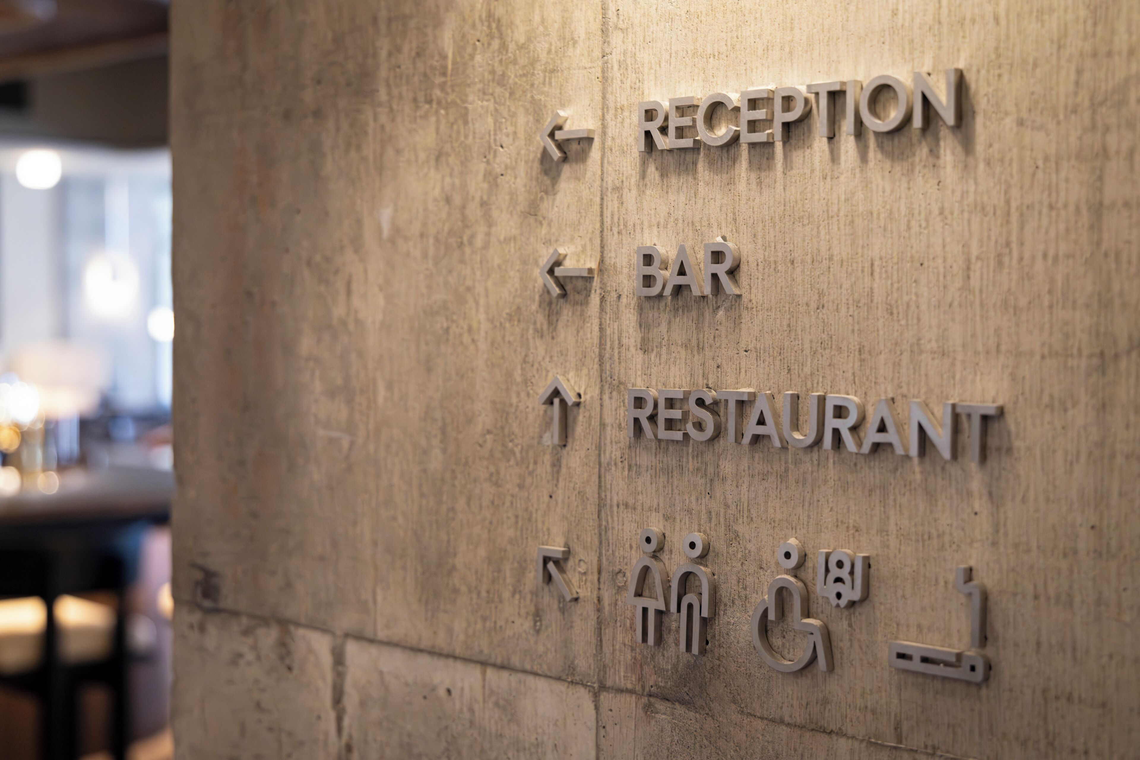 A directional sign with arrows pointing to 'RECEPTION,' 'BAR,' and 'RESTAURANT.'
