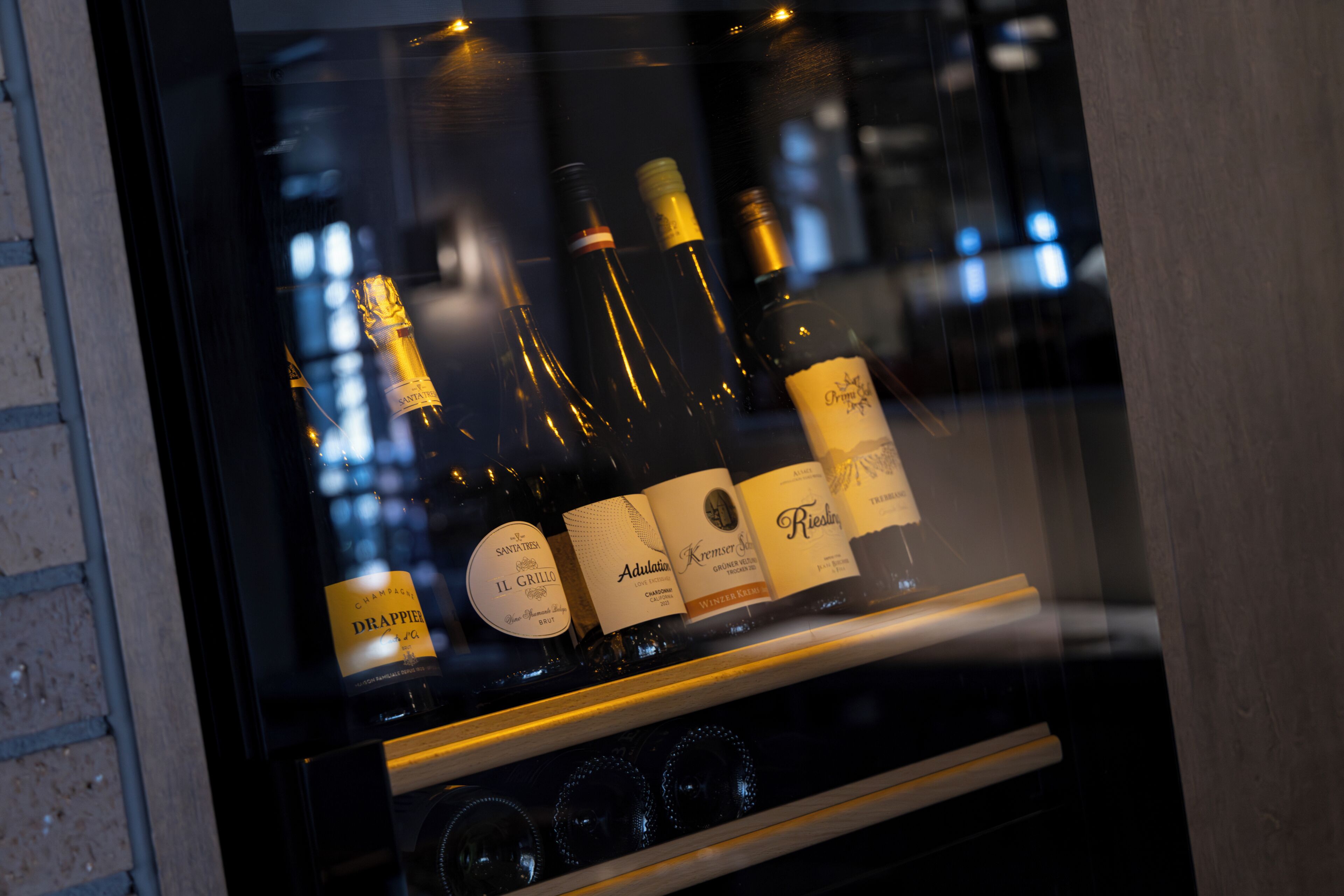 Una botellera con botellas de vino, incluyendo marcas como Il Grillo y Riesling.