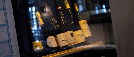 Una botellera con botellas de vino, incluyendo marcas como Il Grillo y Riesling.