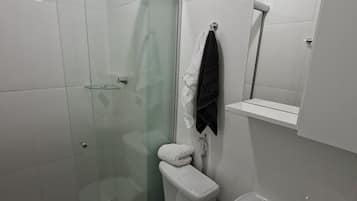 Chuveiro, toalhas de banho, sabonete, papel higiênico