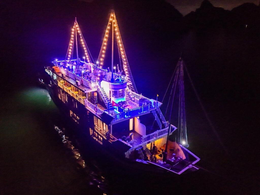 A large, illuminated boat with multiple decks and a central tower, likely used for tours or events.