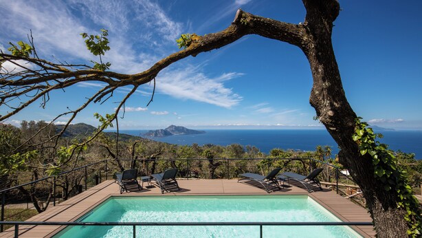 A pool area with lounge chairs and a view of the sea. - Villa Aprea - luxury villa with stunning views and private heated pool (Massa Lubrense)