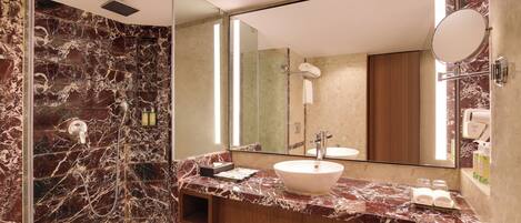 A modern bathroom with a marble vanity, a large mirror, and a glass-enclosed shower.