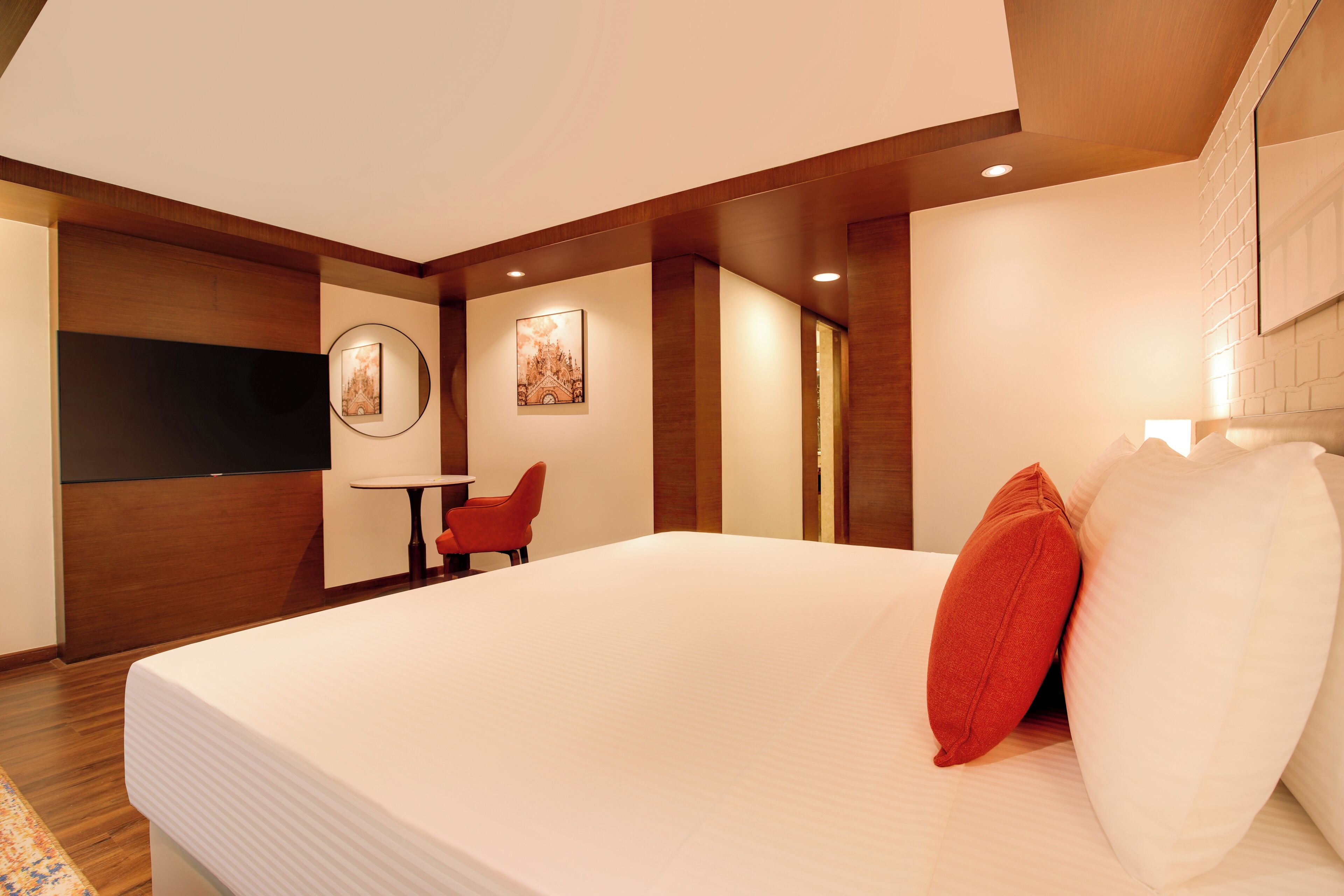 Ein modernes Hotelzimmer mit einem großen Bett, einem Schreibtisch und einem Sessel.