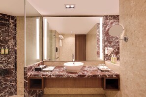 A modern bathroom with a marble vanity, a large mirror, and a built-in sink. - Lemon Tree Premier Navi Mumbai (Navi Mumbai)