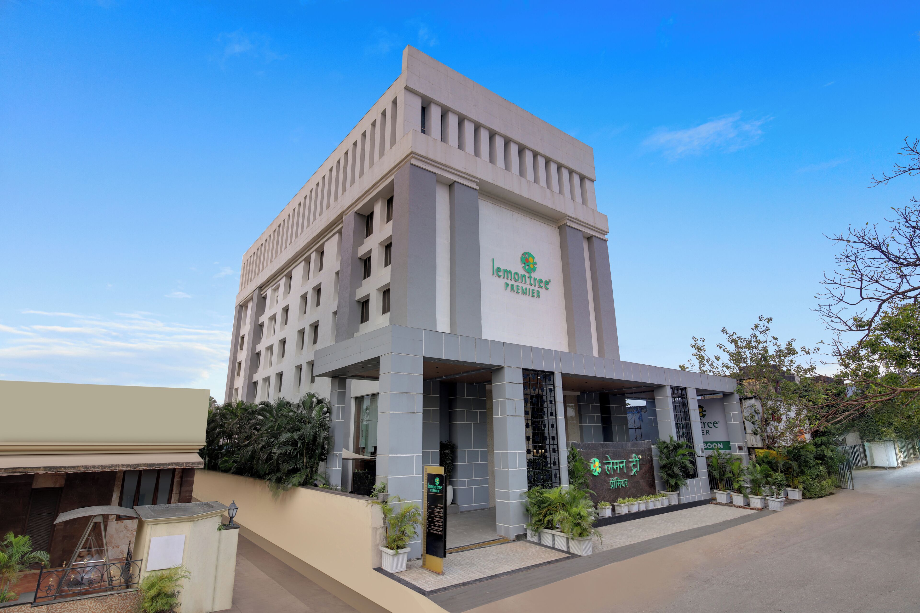 A modern building with a prominent 'lemontree premier' sign, featuring a structured facade and a covered entrance area.