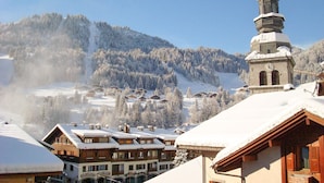 A snow-covered mountain village with wooden buildings and a church tower. - Apartment 6 pers, 2 bdr, 54 m², garage, La Clusaz (La Clusaz)