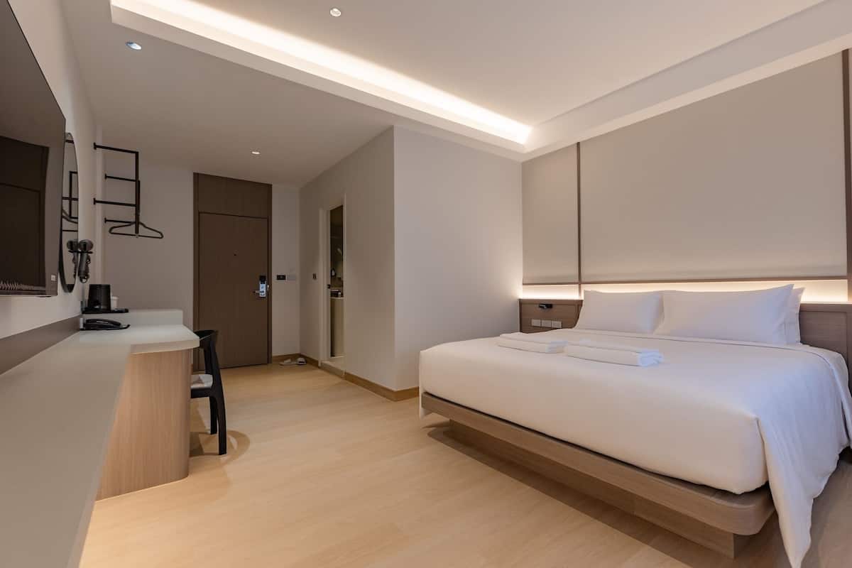 Une chambre d’hôtel moderne, dotée d’un grand lit, d’un bureau et d’une chaise.