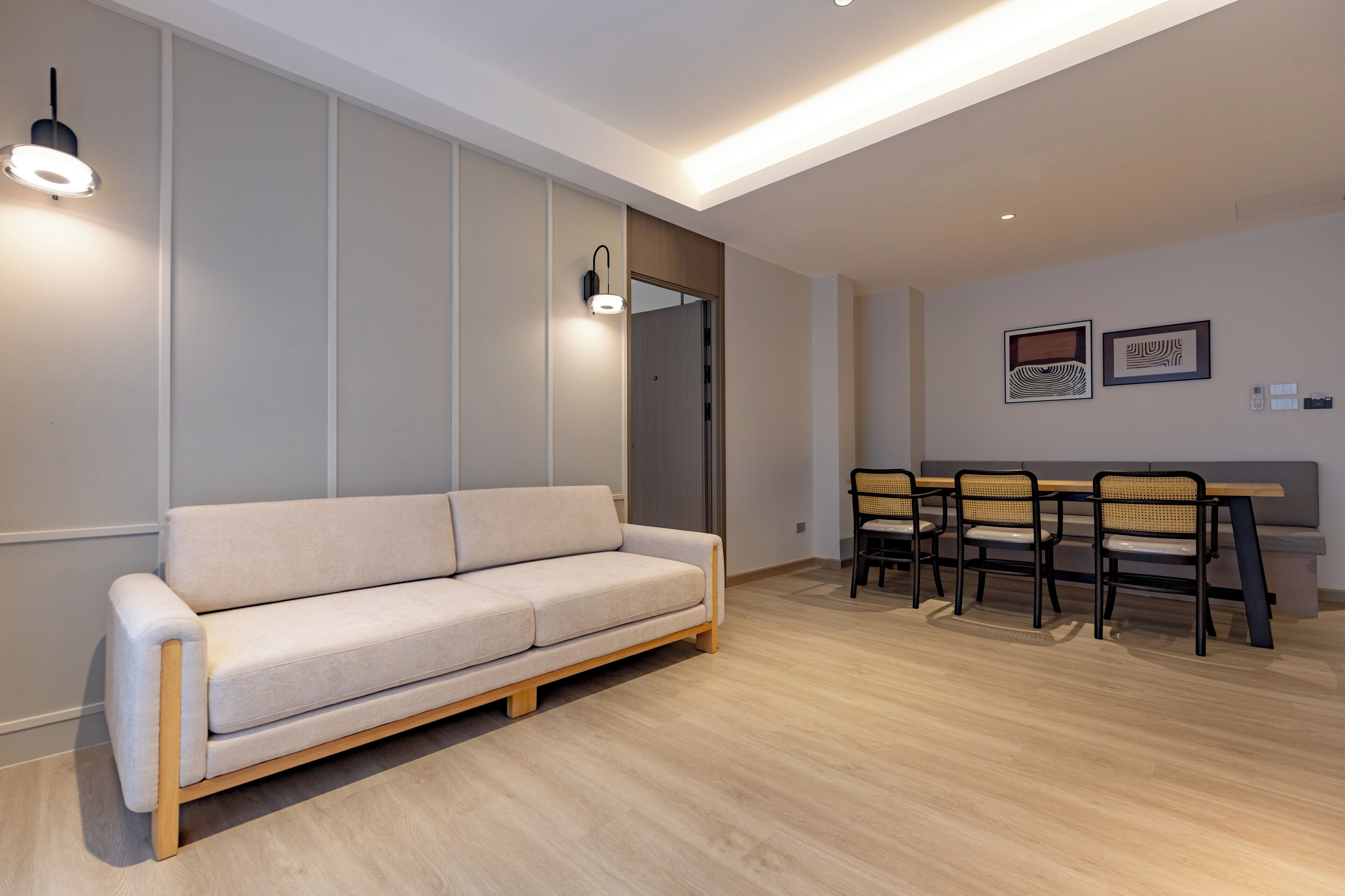A modern living room with a sofa, dining table, and chairs.
