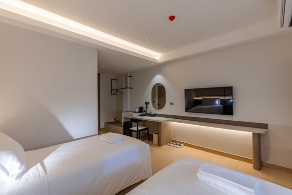A modern hotel room with two beds, a desk, a TV, and a mirror. -  The Bentley Hotel Pratunam (Bangkok)
