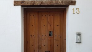 Uma porta de madeira com uma pequena janela e uma caixa de correio na parede.