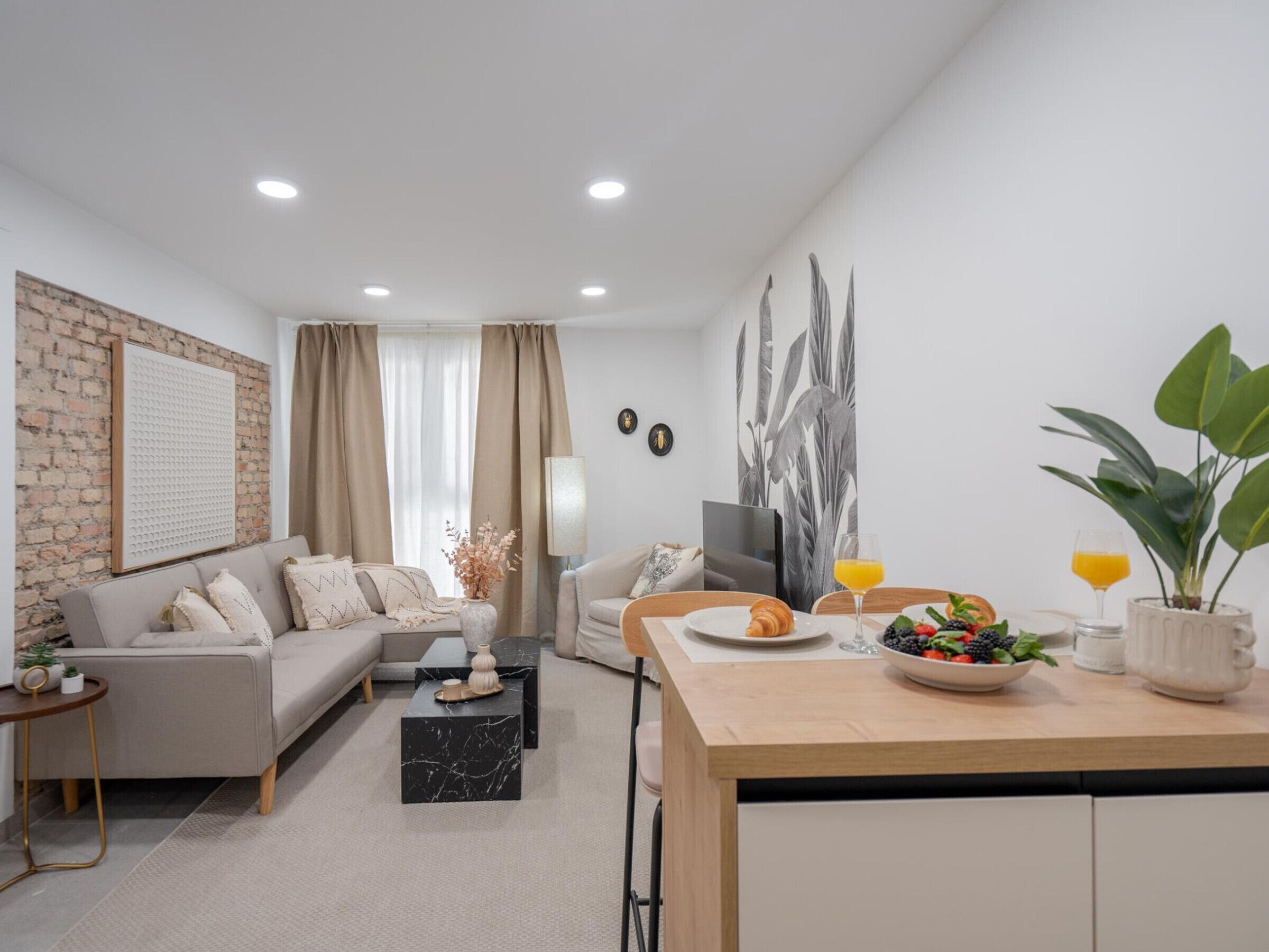 A modern living room with a sofa, coffee table, and dining area.