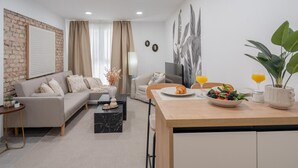 A modern living room with a sofa, coffee table, and dining area.