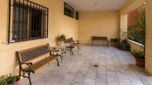 A covered patio area with benches and potted plants. - Charming Apartment in Historical Center Near Granada Cathedral (Granada)