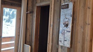 A wooden interior with a sign reading "Aviatz" and a window overlooking a snowy landscape. - Charming 2-room cabin for 6, ski-in/ski-out access (Avoriaz)