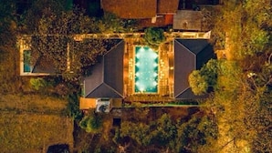 An aerial view of a property with a central swimming pool, surrounded by buildings and trees. - Respira Villaas (Calangute)