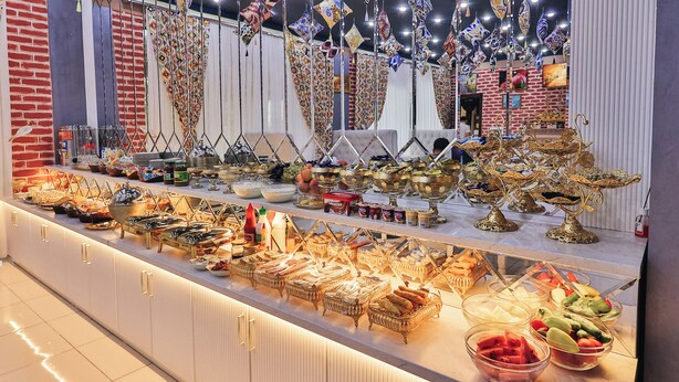 Un bufé con diferentes opciones de comida y adornos colgantes decorativos.