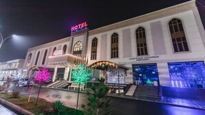Un hotel con un llamativo letrero que dice 'HOTEL', una tienda de bordados 'TOGUYCHILK' y otra tienda de bordados 'KASHTACHILK'.