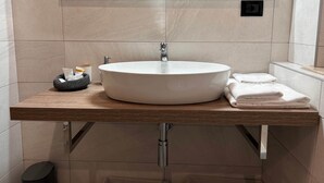 A modern bathroom with a round white sink, a wooden countertop, a black trash bin, and a towel stack. - 3-Room with fireplace (Dwelling 1848-Volta Mantovana) (Volta Mantovana)