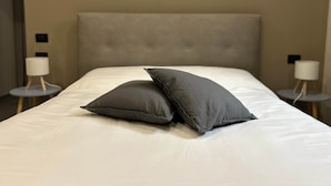 A bed with a grey headboard and two bedside lamps. - 4-Pop room (Dwelling 1848-Volta Mantovana) (Volta Mantovana)