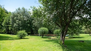 Ein üppiger, grüner Park mit Bäumen und einer Rasenfläche.