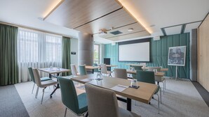 A conference room with a large table, chairs, a projector screen, and a presentation board. - Radisson Hotel Amsterdam Airport Schiphol Hoofddorp (Hoofddorp)