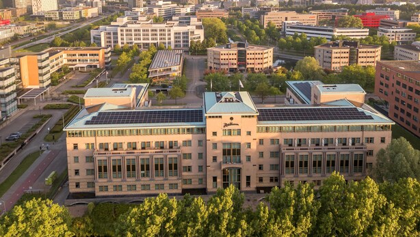 A multi-story building with a central courtyard, surrounded by other buildings, and solar panels on the roof. - Radisson Hotel Amsterdam Airport Schiphol Hoofddorp (Hoofddorp)
