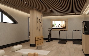 Un gimnasio moderno con equipo de ejercicio, una televisión grande y suelo de madera.