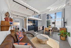 A modern living space with a sofa, coffee table, and dining area.