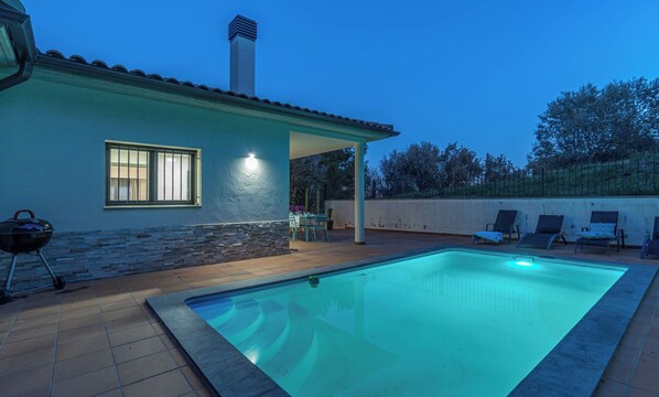 A swimming pool with a tiled deck, a covered patio area, and a barbecue grill. - Jouvacations Villa Rodil (Figueres)