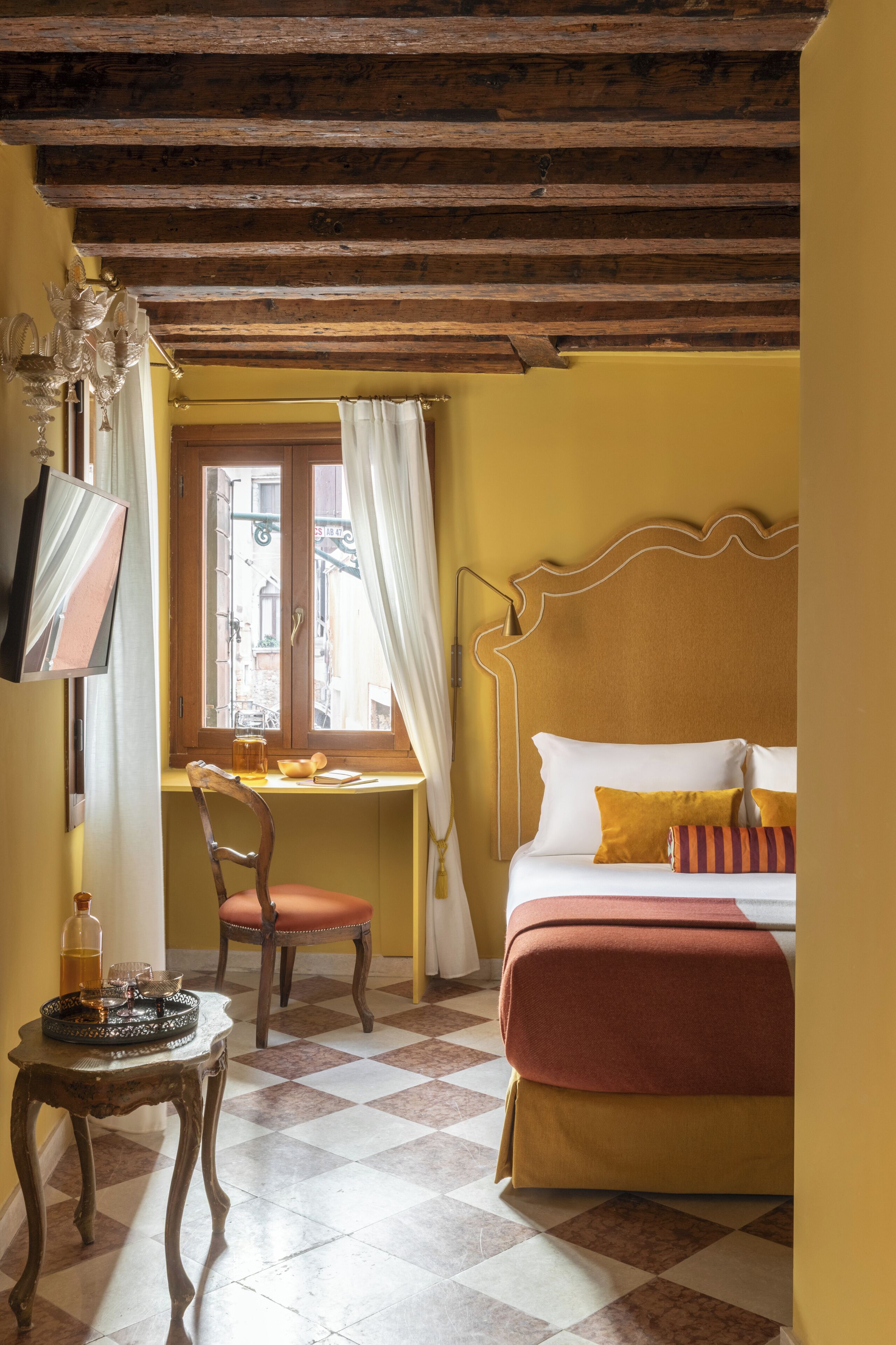 A room with a bed, a desk, a chair, and a table.
