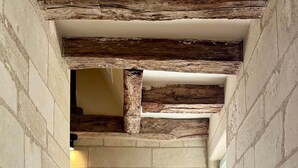 A stone staircase with a rustic wooden beam ceiling and a window at the top. - Guest Room Sable - Auberge Radieuse (Azay-le-Rideau)