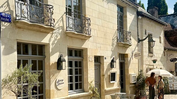 A building with a stone facade, multiple windows, and outdoor seating. - Guest Room Bleue - Auberge Radieuse (Azay-le-Rideau)