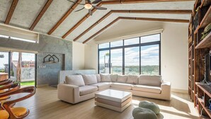 A spacious living room with a large sectional sofa, a coffee table, and a ceiling fan.