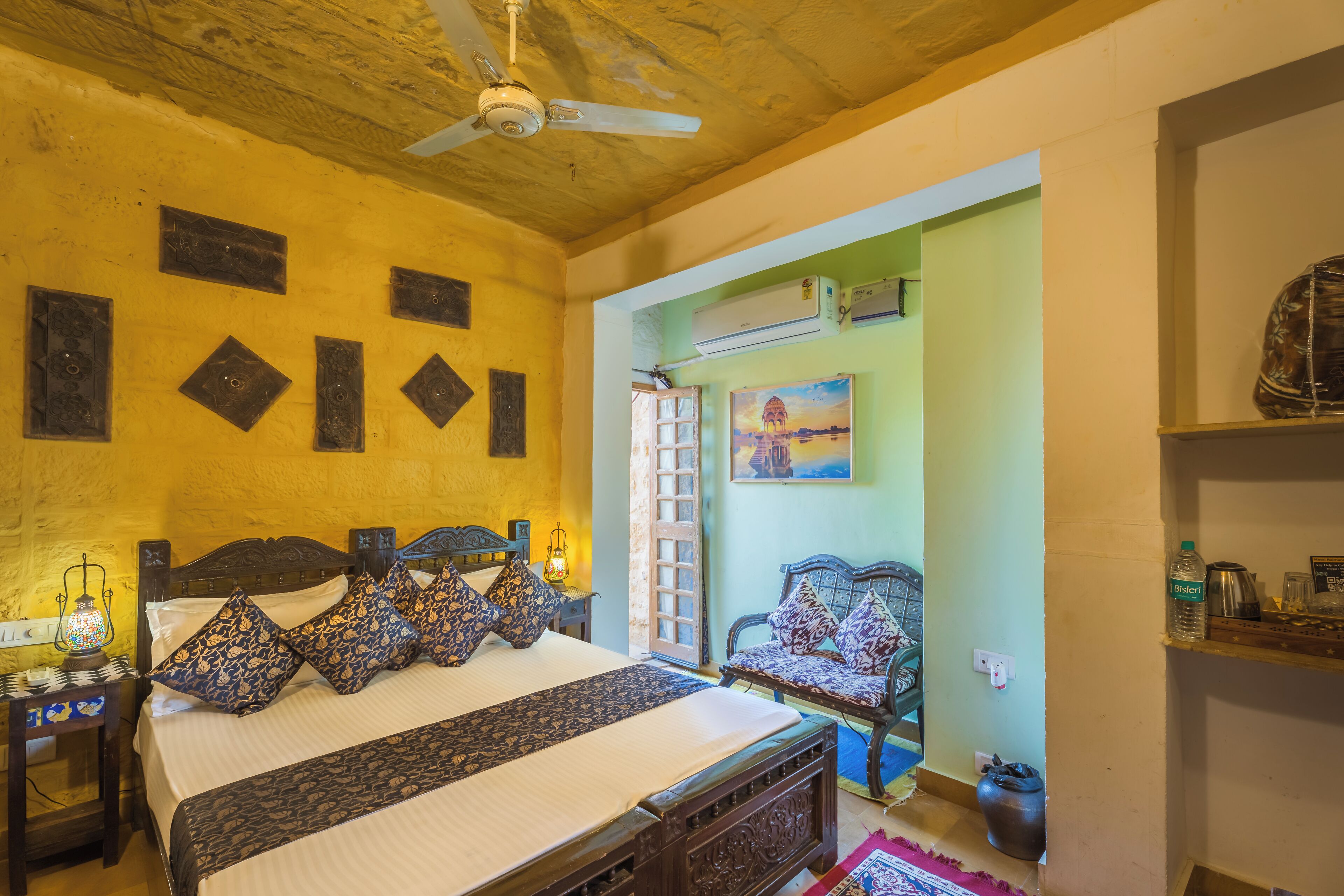 Una habitación con cama, una silla, una mesa y un ventilador de techo.