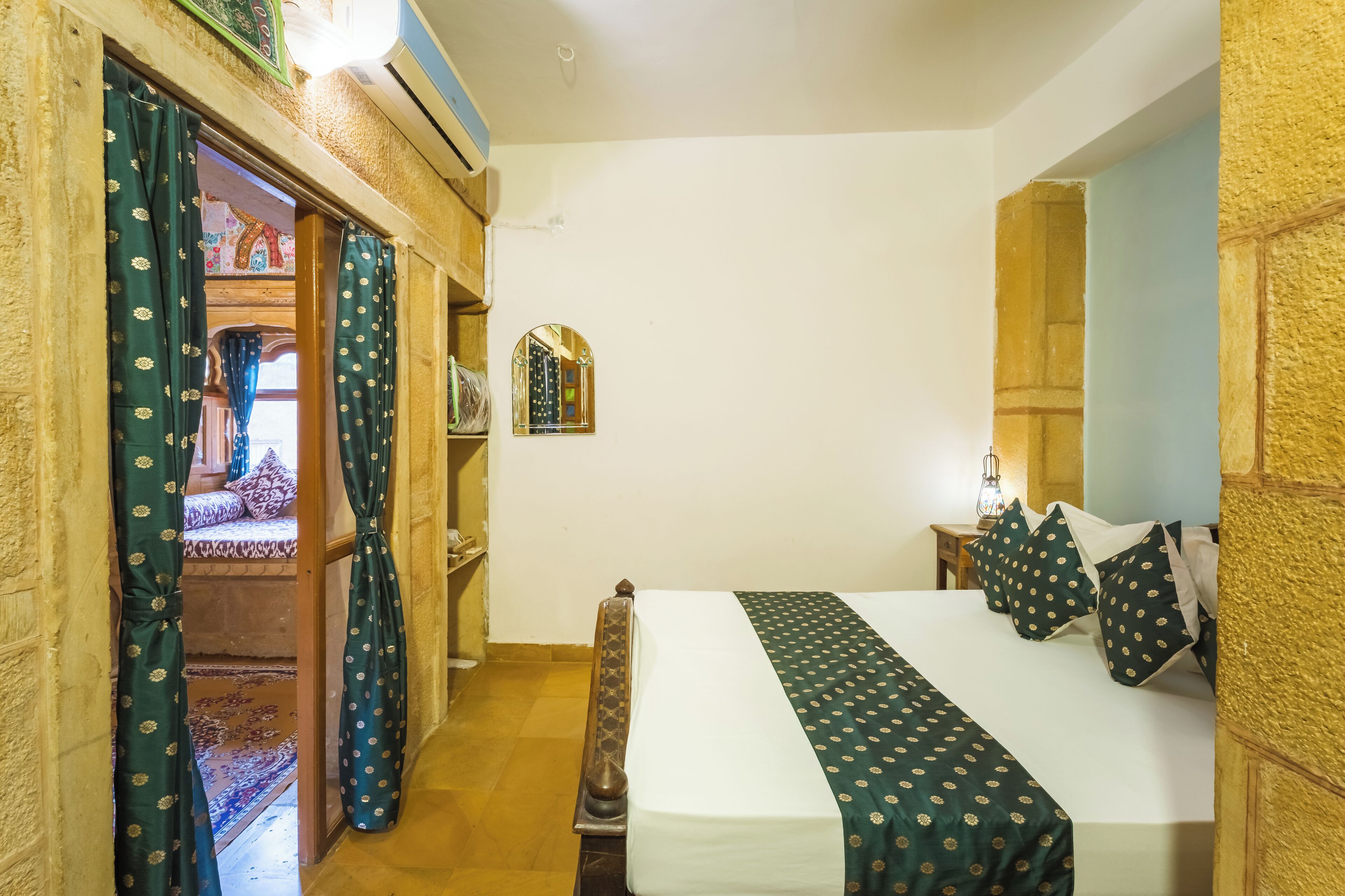 A hotel room with a bed, a mirror, a window, and a door leading to a balcony.