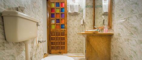 A bathroom with a toilet, sink, and a mirror.