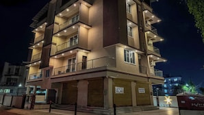 A multi-story residential building with balconies, ground-level shops, and a gated entrance. - RK Homes Service Apartments (Vasco da Gama)