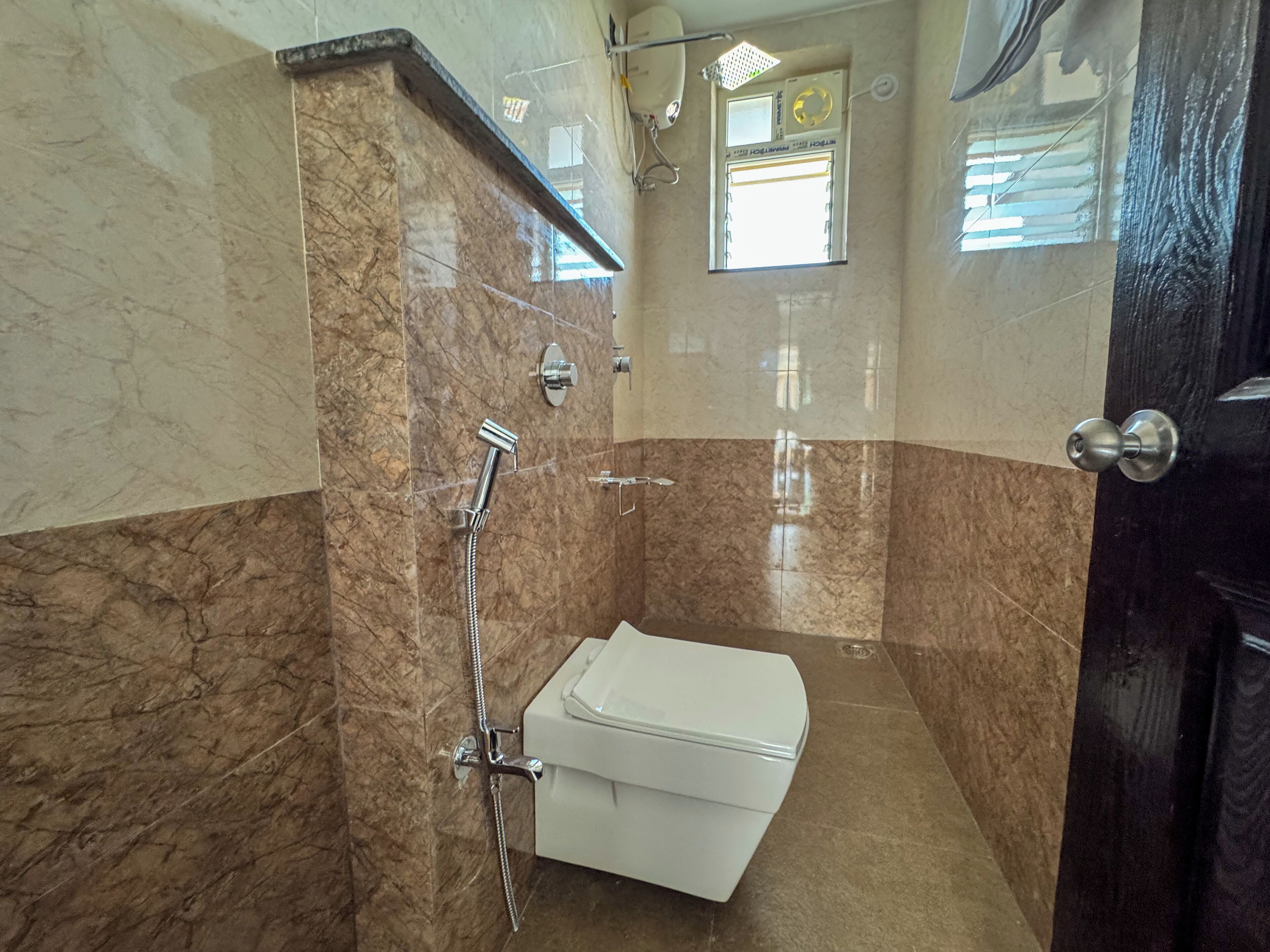 Une salle de bain avec une douche, des toilettes et un miroir.