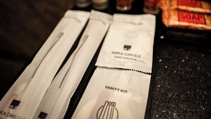 A vanity kit with toiletries on a dark countertop.